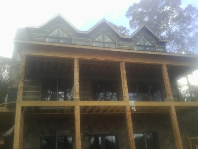 Dormers and porch framing on a large log home under construction — Roof Coating work by our crew in Snoqualmie