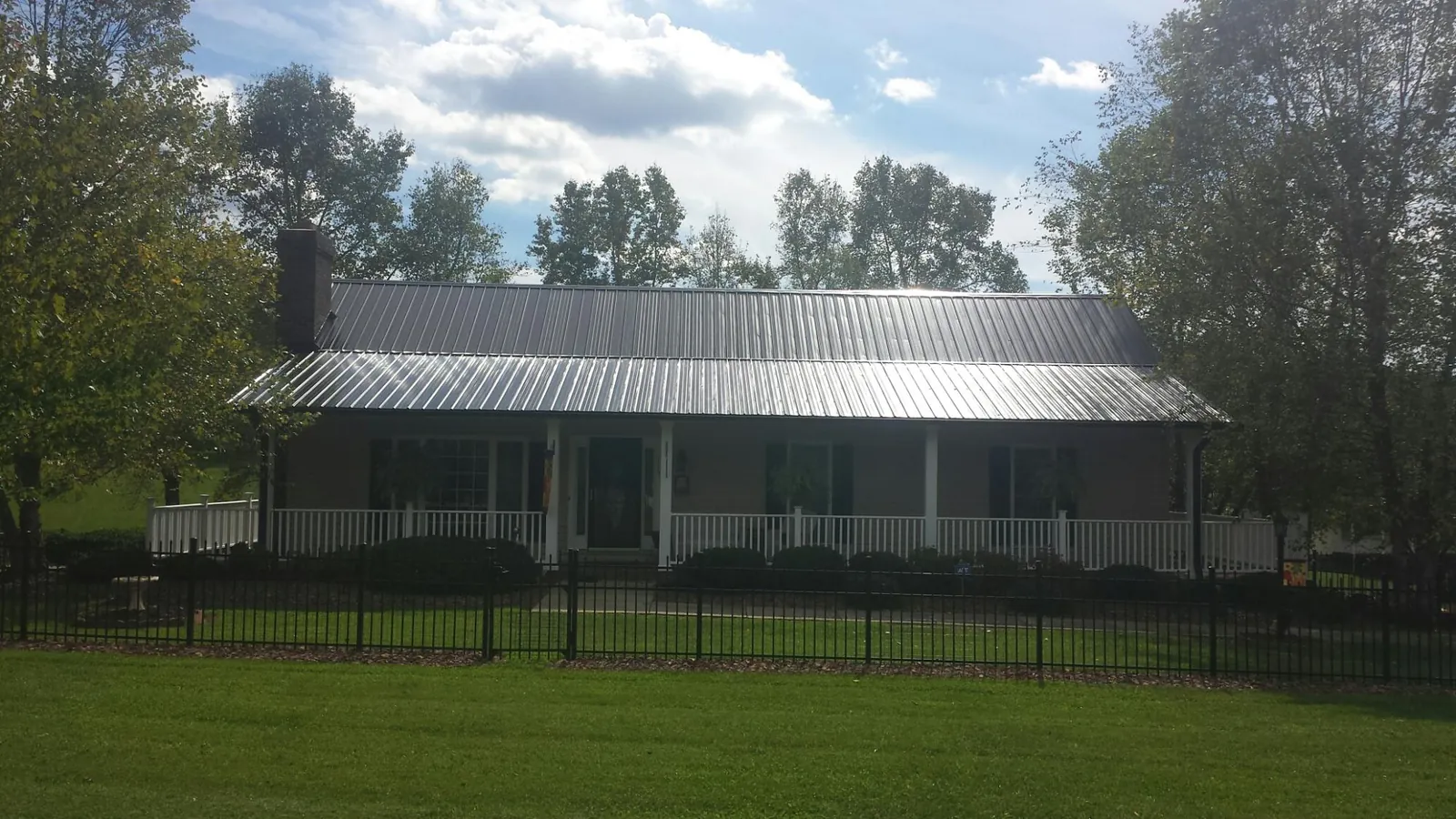 Gray metal roof on a brick ranch with a full width front porch — Gutter Guard Installation work by our crew in Snoqualmie
