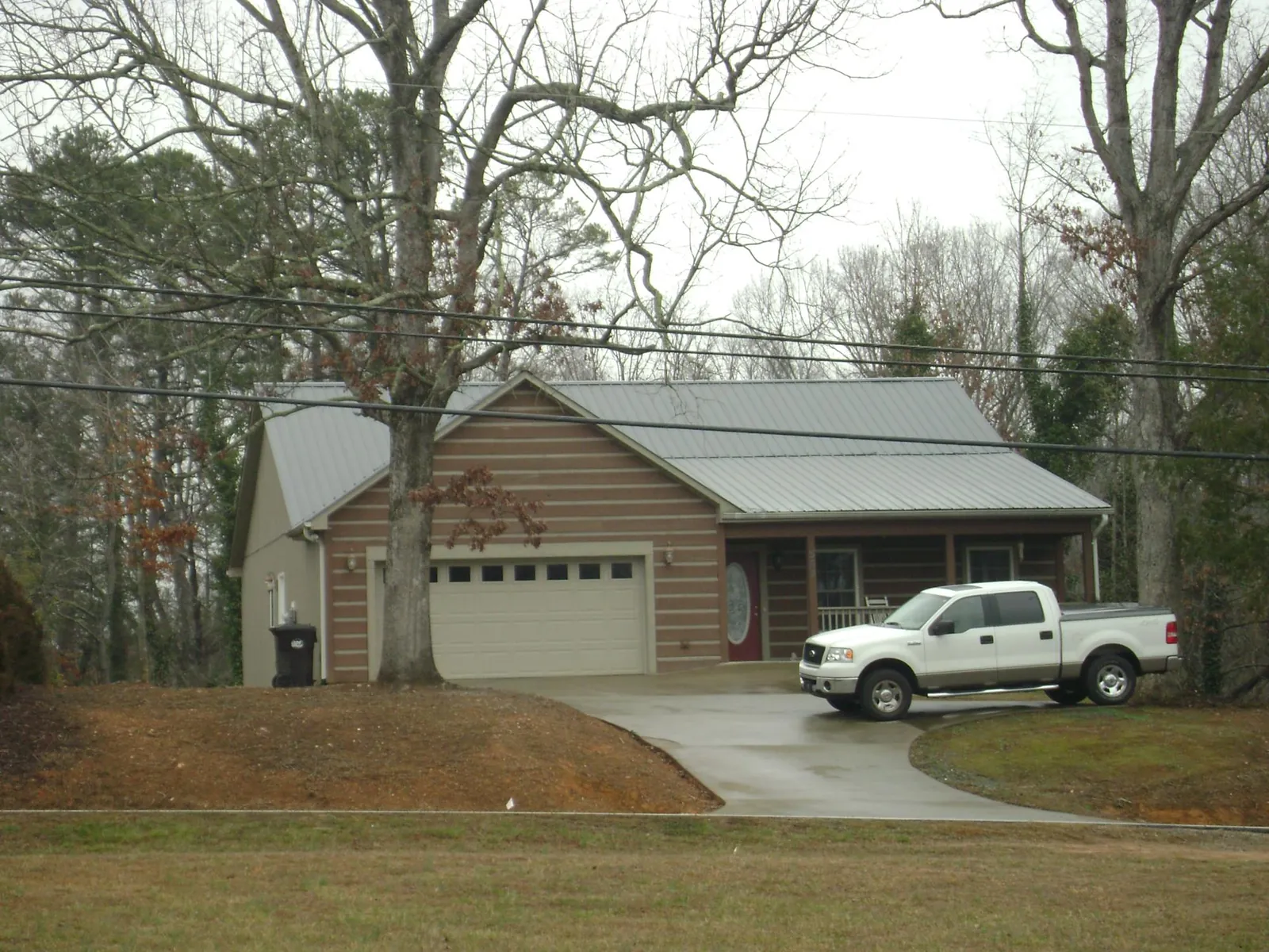 Gray metal roof on a log sided house with an attached two car garage in Snoqualmie